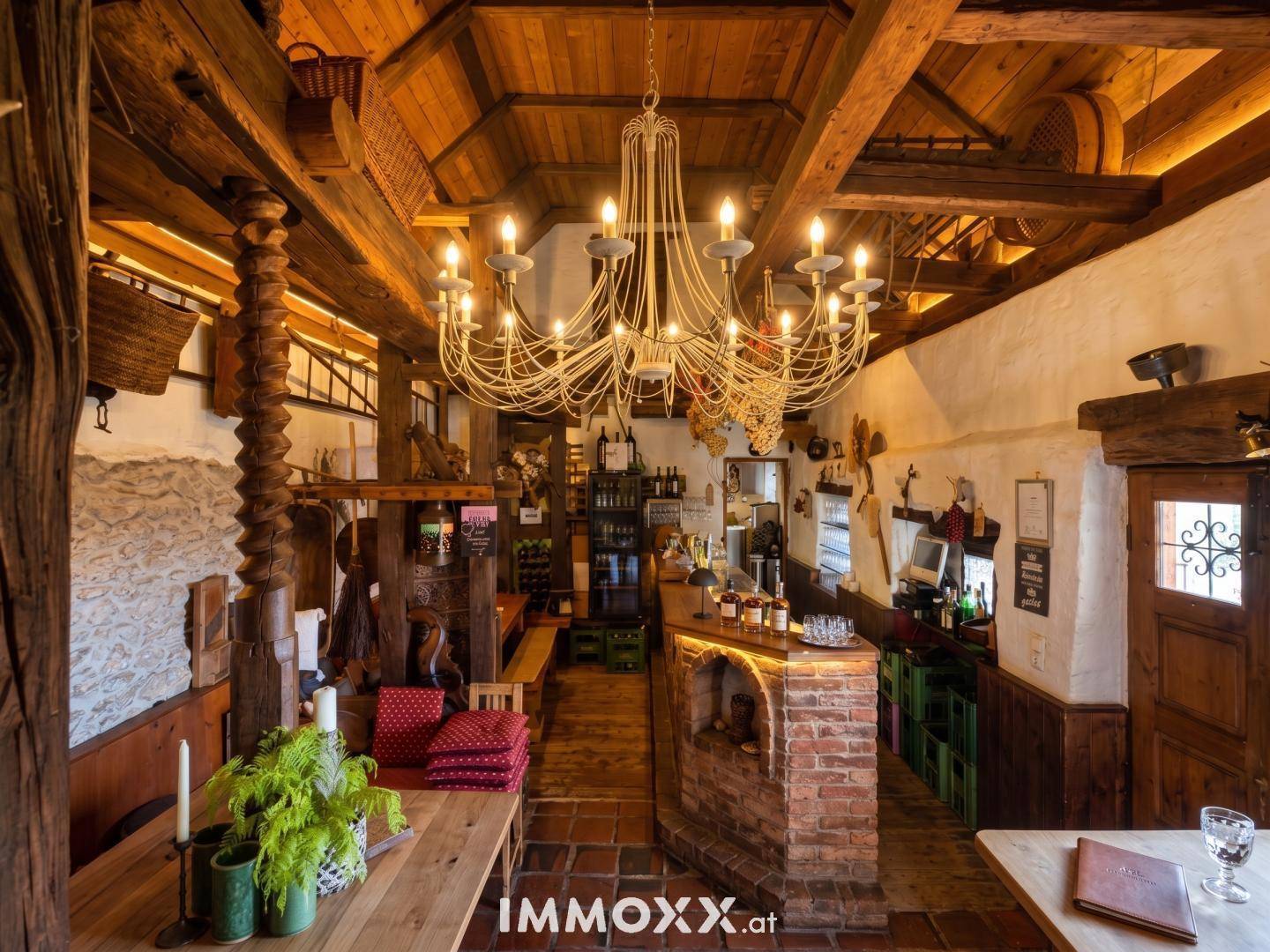 Rustikaler Innenraum mit Holzbalkendecke, Ziegeltheke und traditioneller Einrichtung, ideal für gesellige Runden.