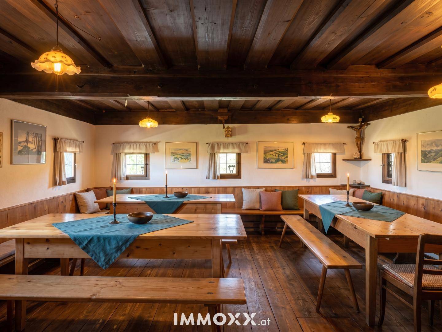 Traditioneller Speisesaal mit langen Holztischen, Bänken und einer rustikalen Holzbalkendecke.