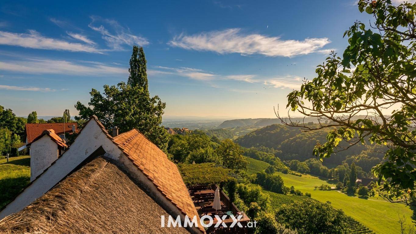Blick über die Dächer des Anwesens mit Ziegel- und Strohdach, umgeben von einer weiten grünen Landschaft.