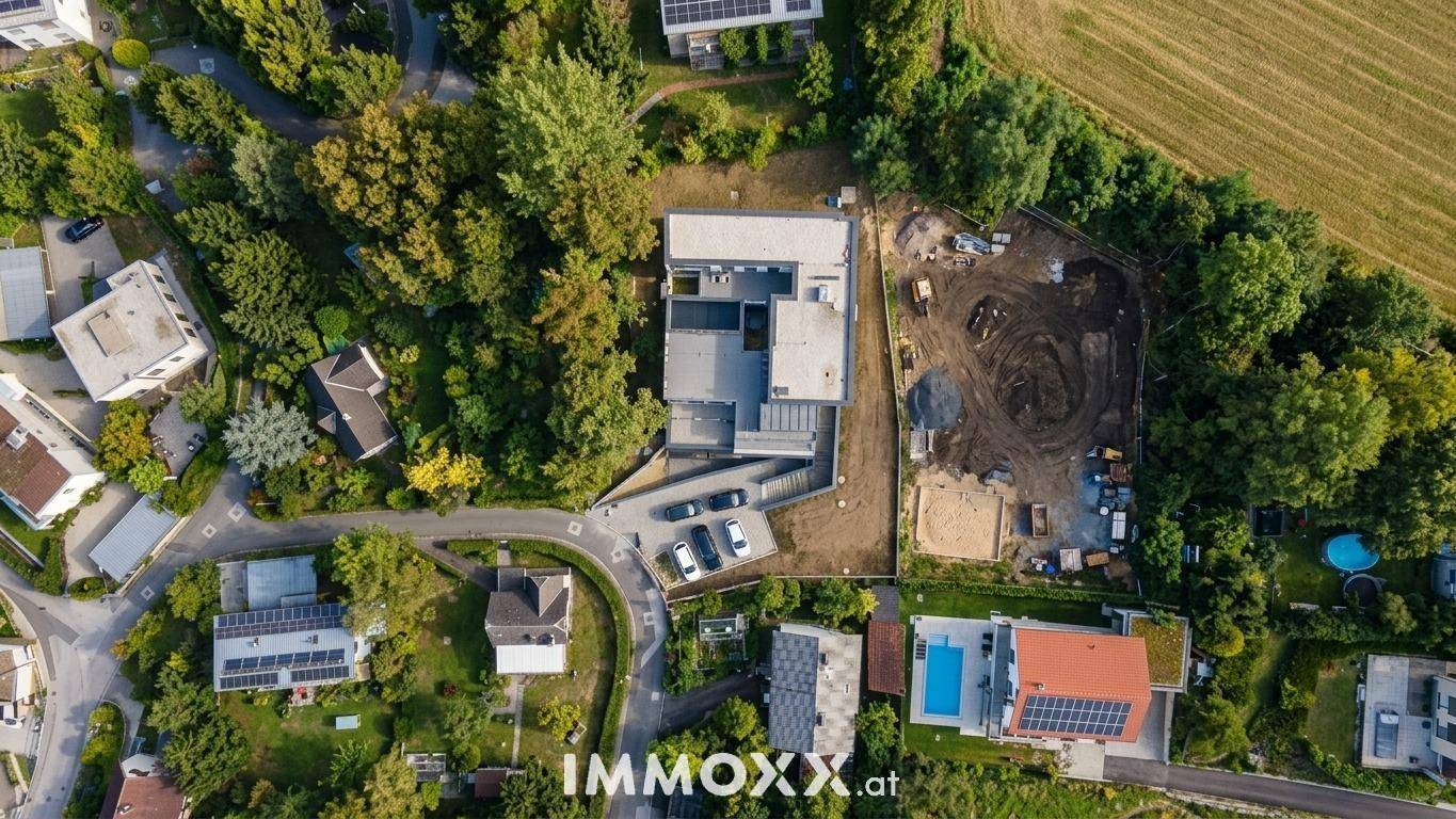 Vogelperspektive des Anwesens und der Umgebung, mit angrenzender Baustelle und viel Grün.