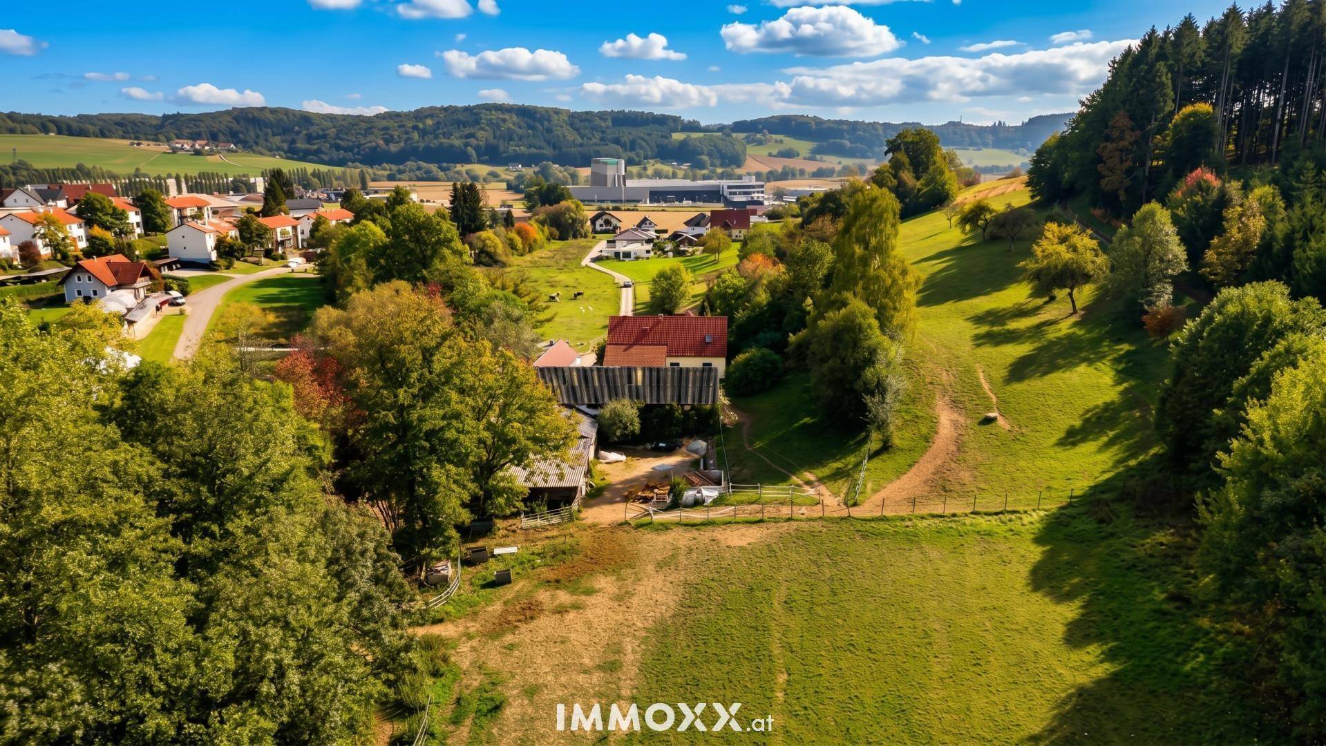 Panoramablick auf das Anwesen und die umliegende ländliche Siedlung mit viel Grün.