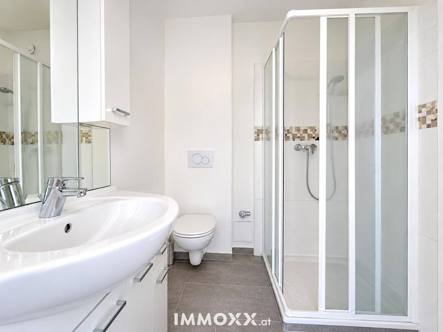 Modernes Badezimmer mit Duschkabine, wandhängendem WC und Waschbecken.