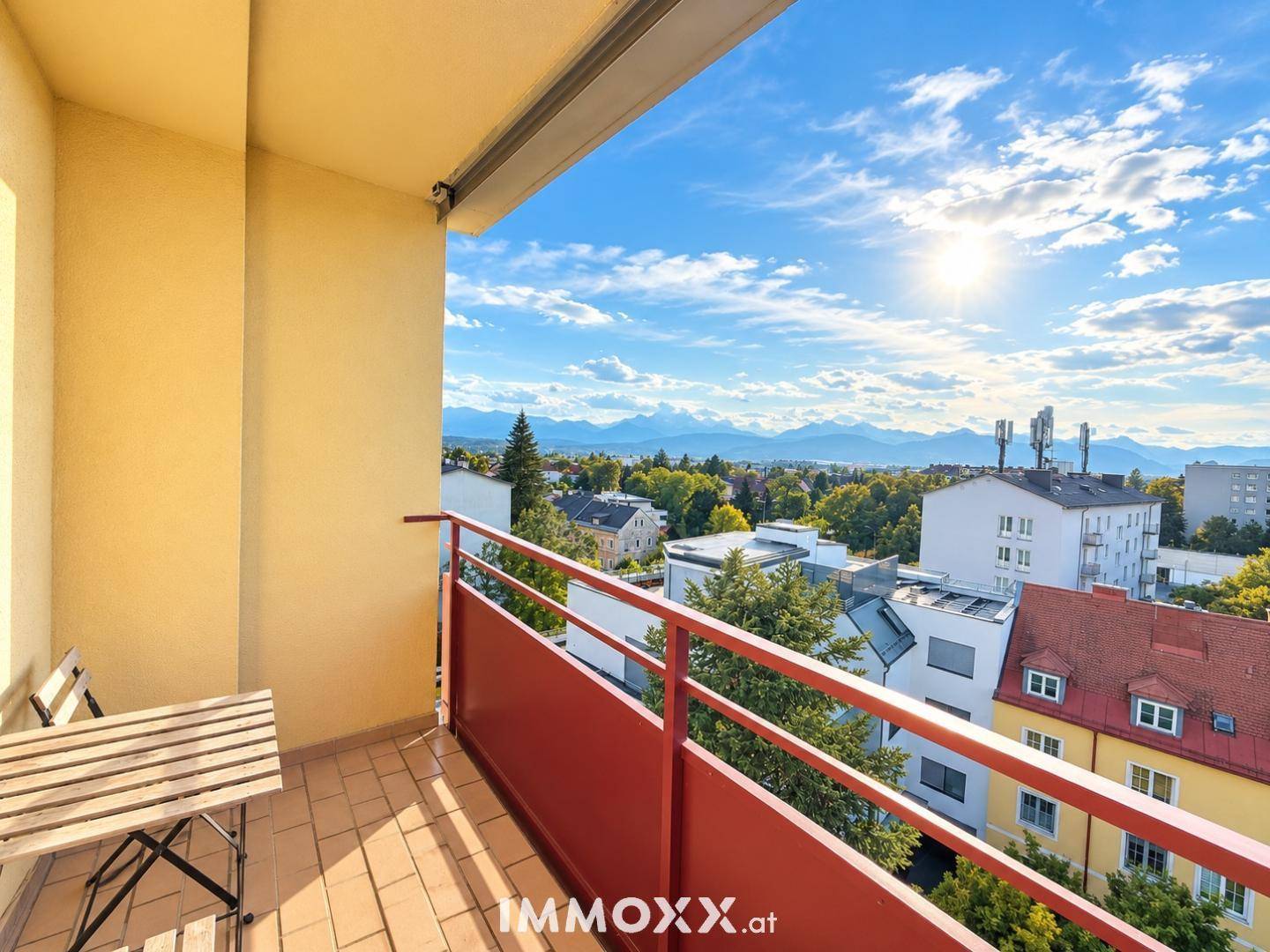 Sonniger Balkon mit Bergblick, Stadtpanorama und kleinem Tisch für entspannte Stunden.