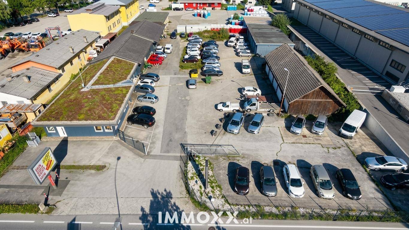 Luftaufnahme eines Gewerbegebiets mit Gebäuden, Parkplätzen und einem Gebäude mit begrüntem Dach.