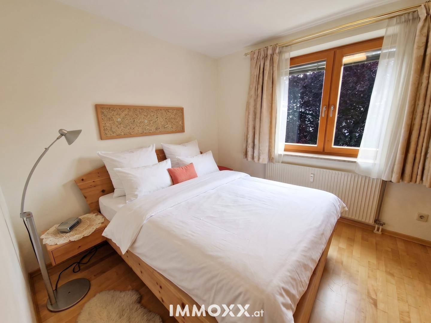 Helles Schlafzimmer mit Holzbett und schlichter Einrichtung, bietet eine ruhige Atmosphäre.