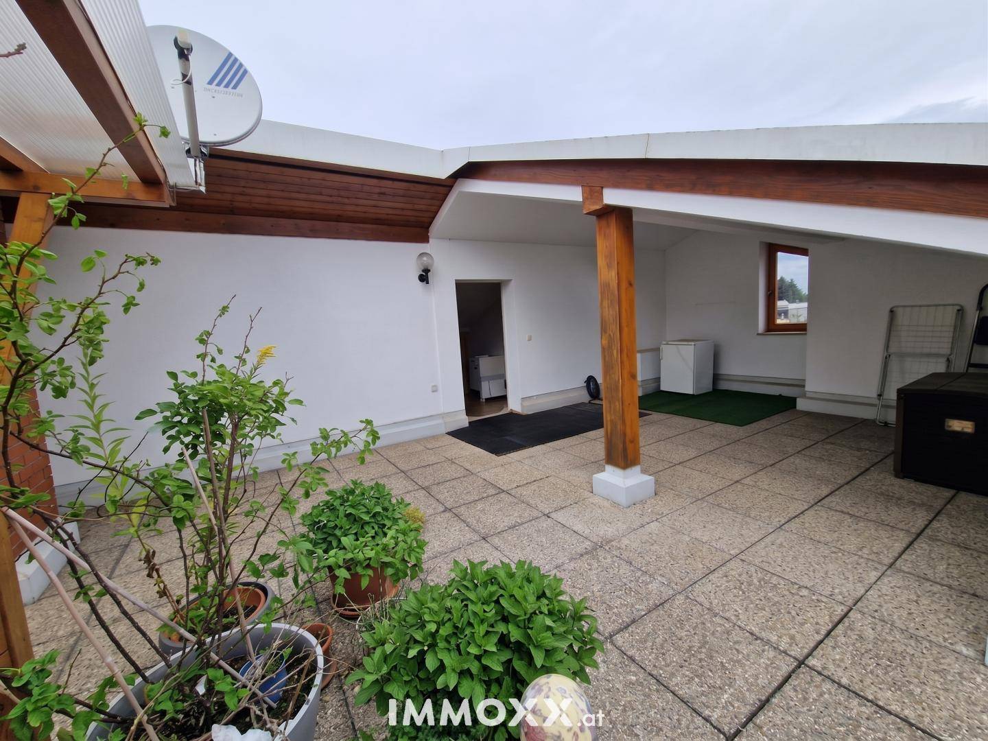 Weitläufige Dachterrasse mit Fliesenboden und verschiedenen Topfpflanzen, bietet einen schönen Ausblick.