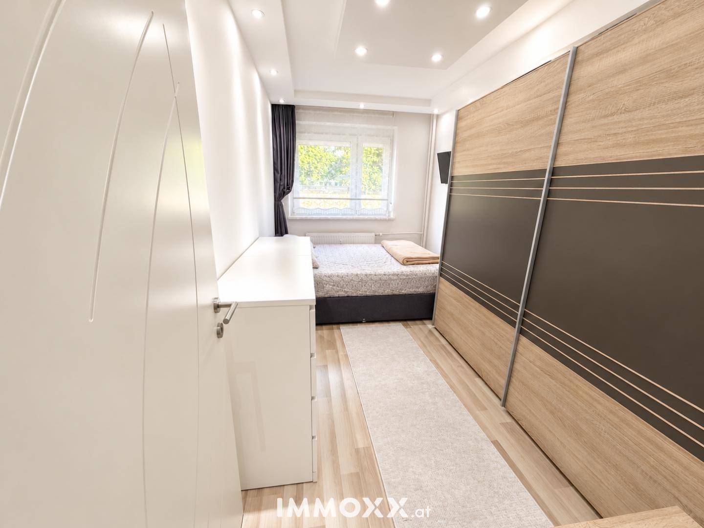Gemütliches Schlafzimmer mit großem Schiebeschrank und hellem Laminatboden.