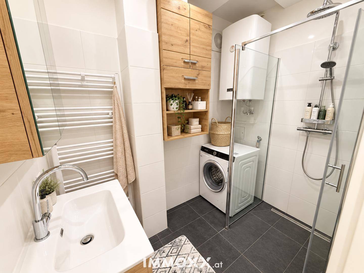Modernes Badezimmer mit ebenerdiger Dusche, Waschmaschine und Holzschränken.
