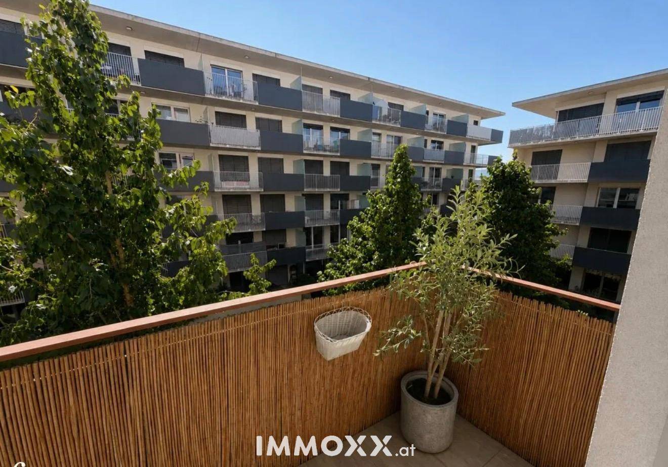 Kleiner Balkon mit Bambusverkleidung und Blick auf die umliegenden Gebäude.