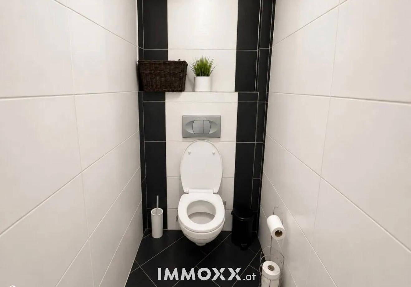 Modern gefliestes Gäste-WC in Schwarz-Weiß mit Wand-WC.
