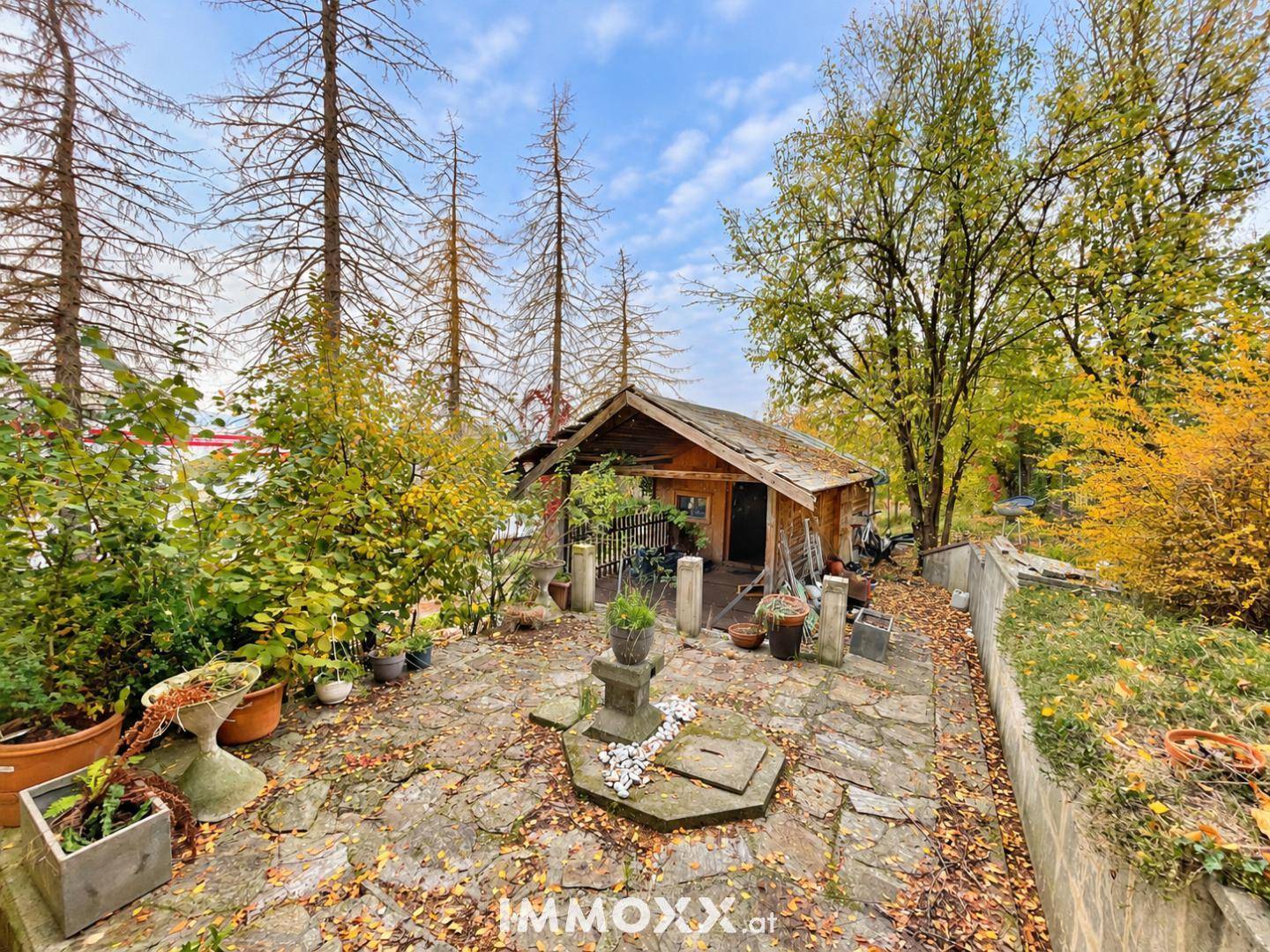 Herbstlicher Garten mit rustikalem Holzschuppen