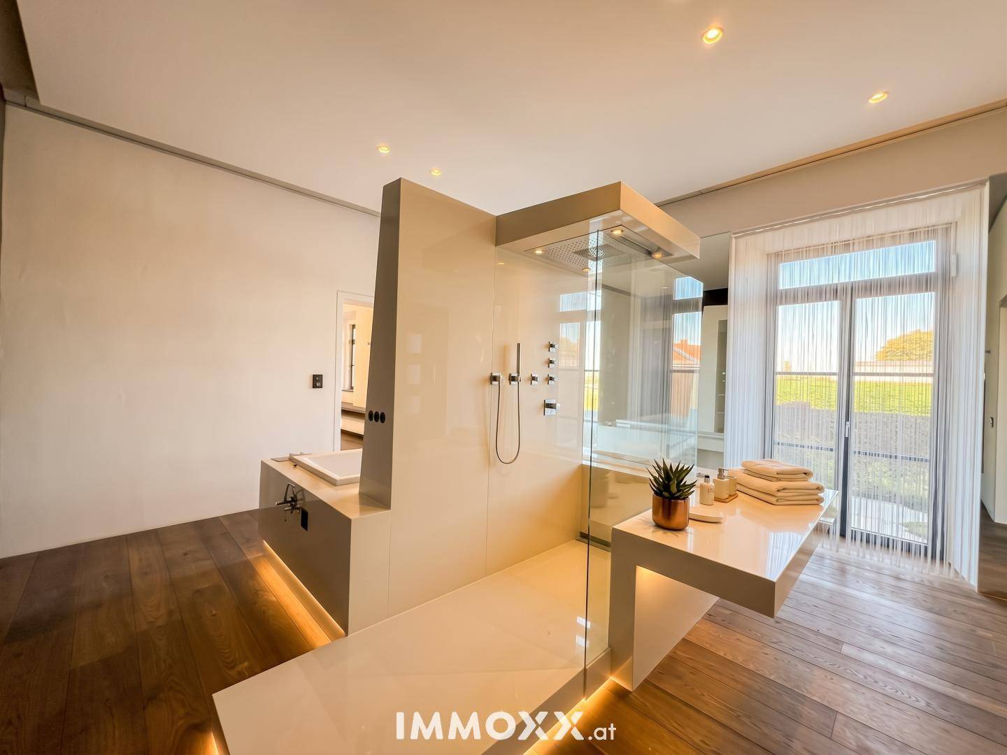 Modernes Badezimmer mit begehbarer Dusche, minimalistischem Design und Holzboden.