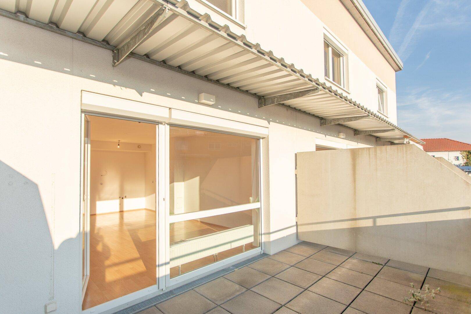 Große, geflieste Terrasse mit viel Sonnenlicht und Zugang zum Innenbereich, bietet Platz im Freien.