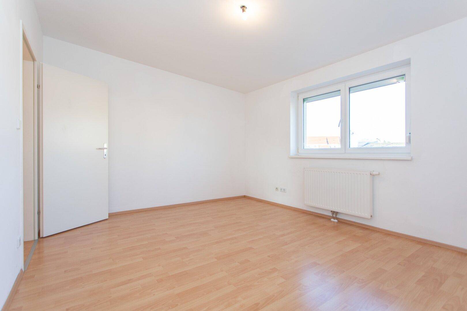 Geräumiges Schlafzimmer mit Fenster und Heizkörper, bietet eine angenehme Wohnatmosphäre.