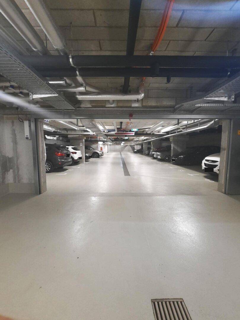 Geräumige Tiefgarage mit zahlreichen Parkplätzen und moderner Beleuchtung.