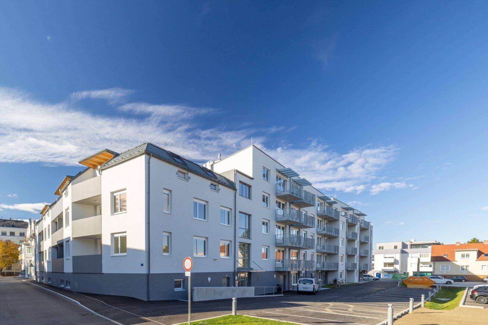 Modernes Wohnhaus mit mehreren Balkonen und einer gepflegten Außenanlage, einladendes Erscheinungsbild.