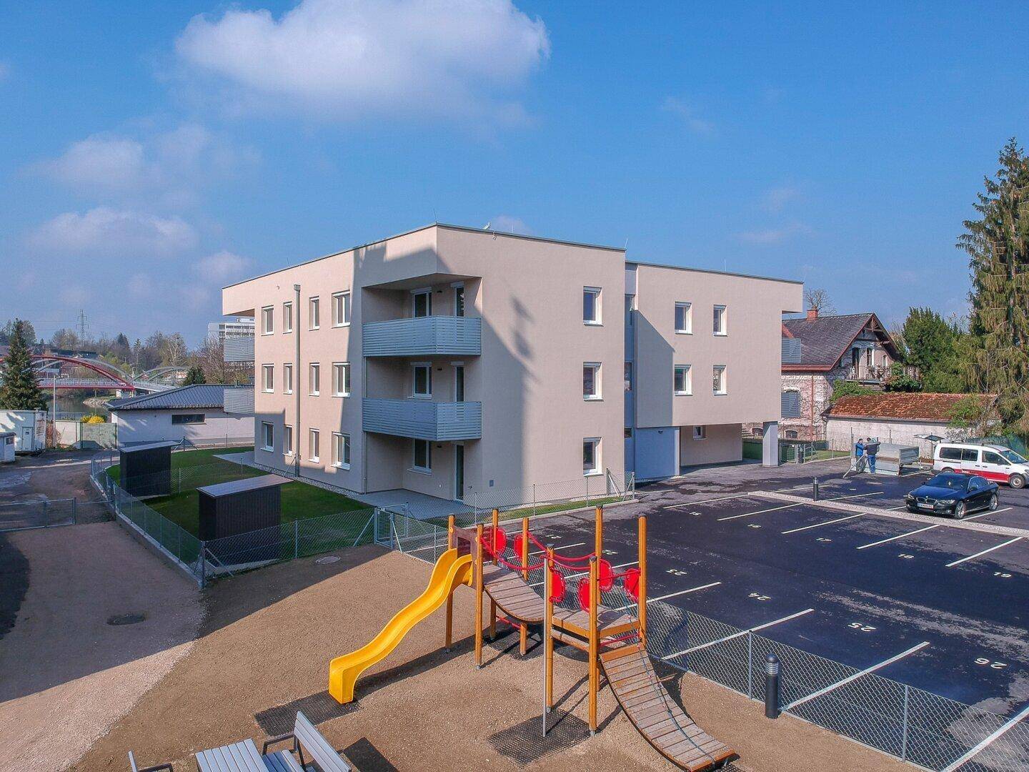 Luftaufnahme des modernen Wohnkomplexes mit Kinderspielplatz und ausreichend Parkmöglichkeiten.