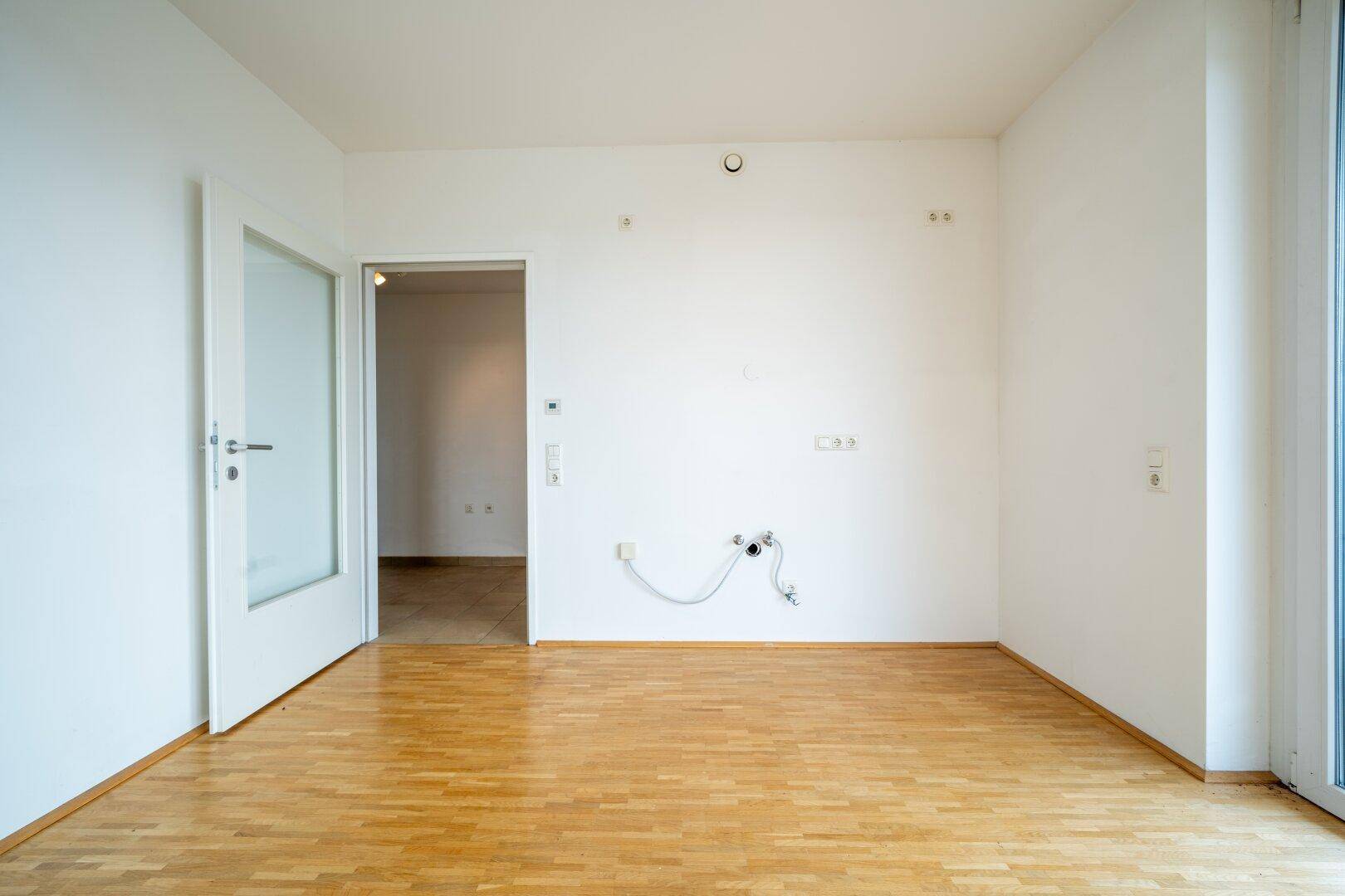Leerer Raum mit Parkettboden und weißen Wänden, vorbereitet für individuelle Nutzung.