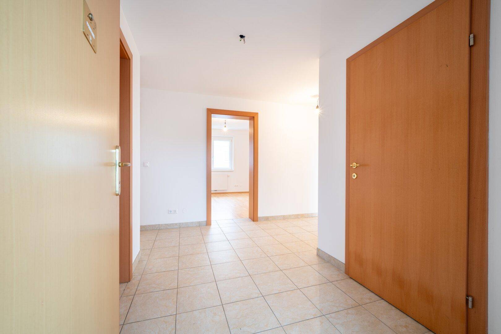 Eingangsbereich mit Fliesenboden und Blick in die angrenzenden Zimmer, hell und einladend.