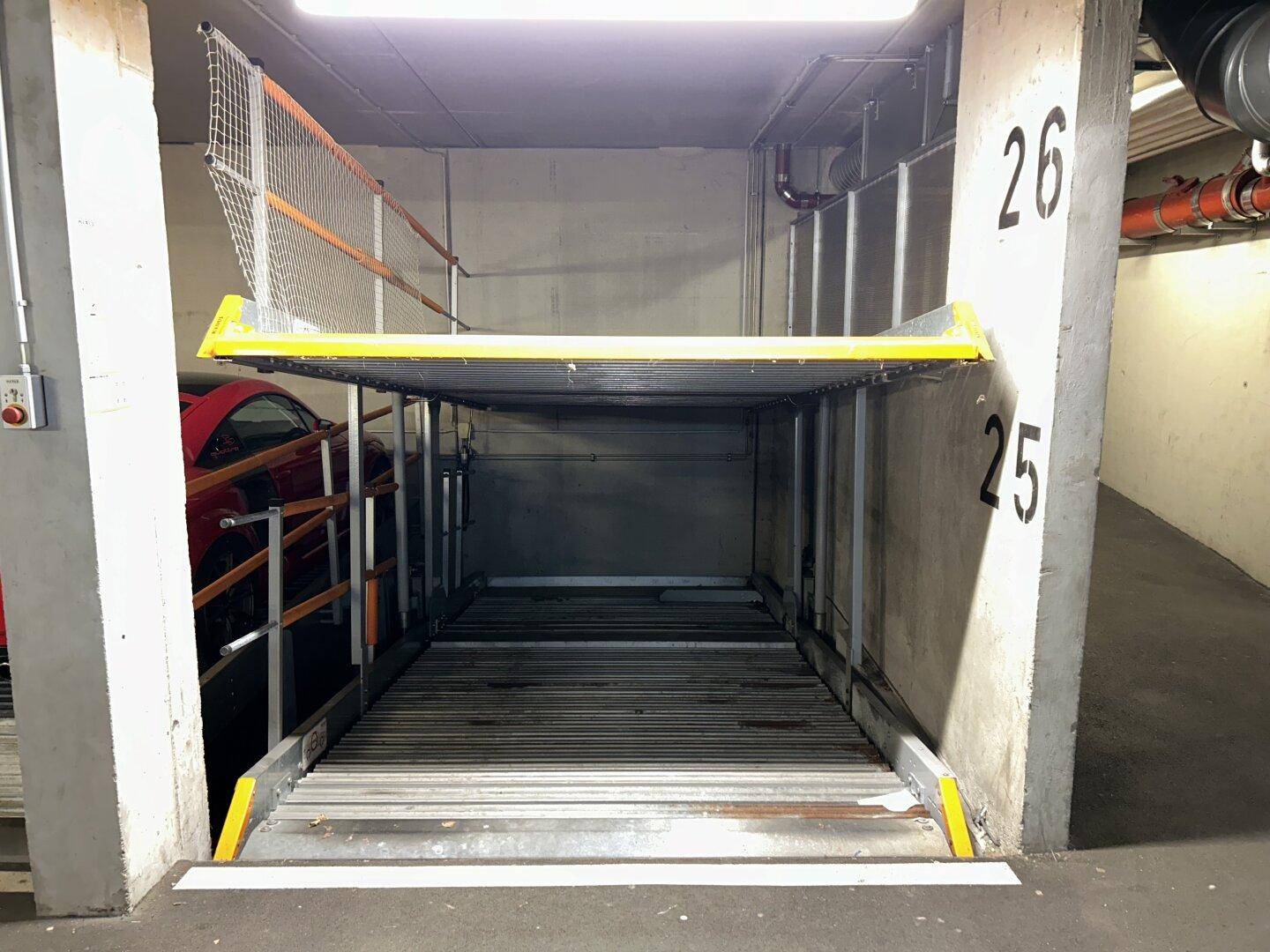Mechanisches Doppelparker-System in einer Tiefgarage mit einem Fahrzeug auf der oberen Ebene.