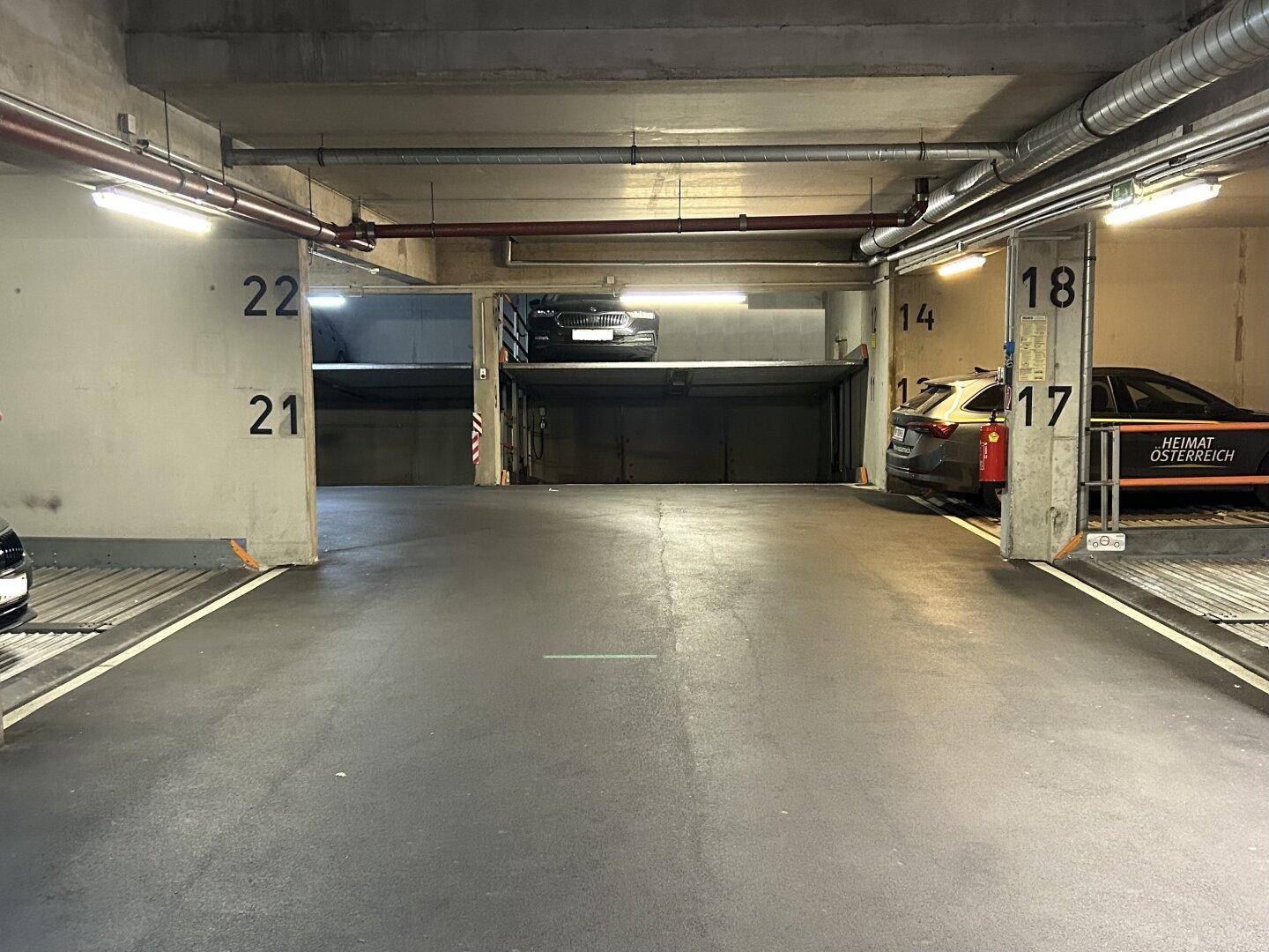 Tiefgarage mit mehreren mechanischen Doppelparker-Systemen und geparkten Fahrzeugen.
