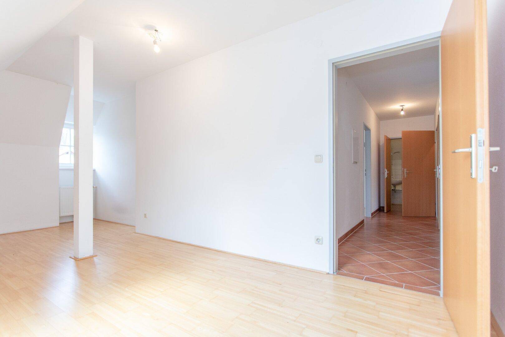 Heller Flur mit Terracotta-Fliesenboden, der zu weiteren Räumen und einem Badezimmer führt.