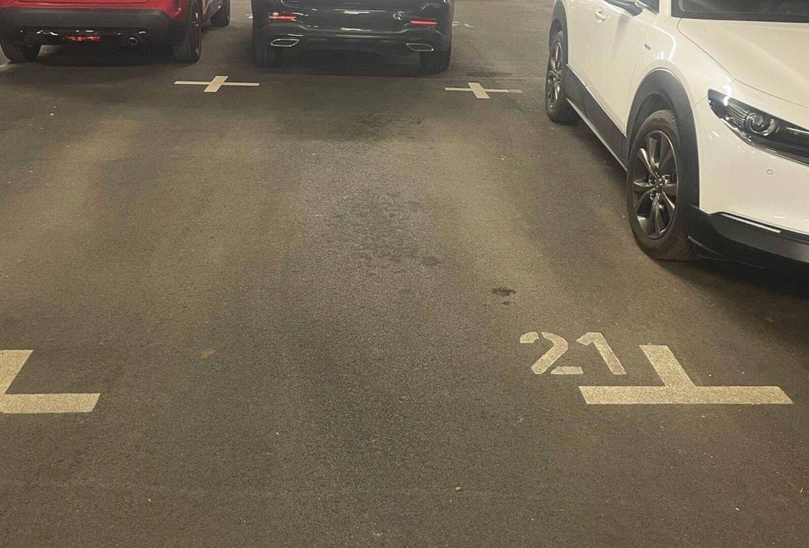 Blick auf die Stellplätze in der Tiefgarage mit geparkten Fahrzeugen und deutlichen Markierungen auf dem Boden.