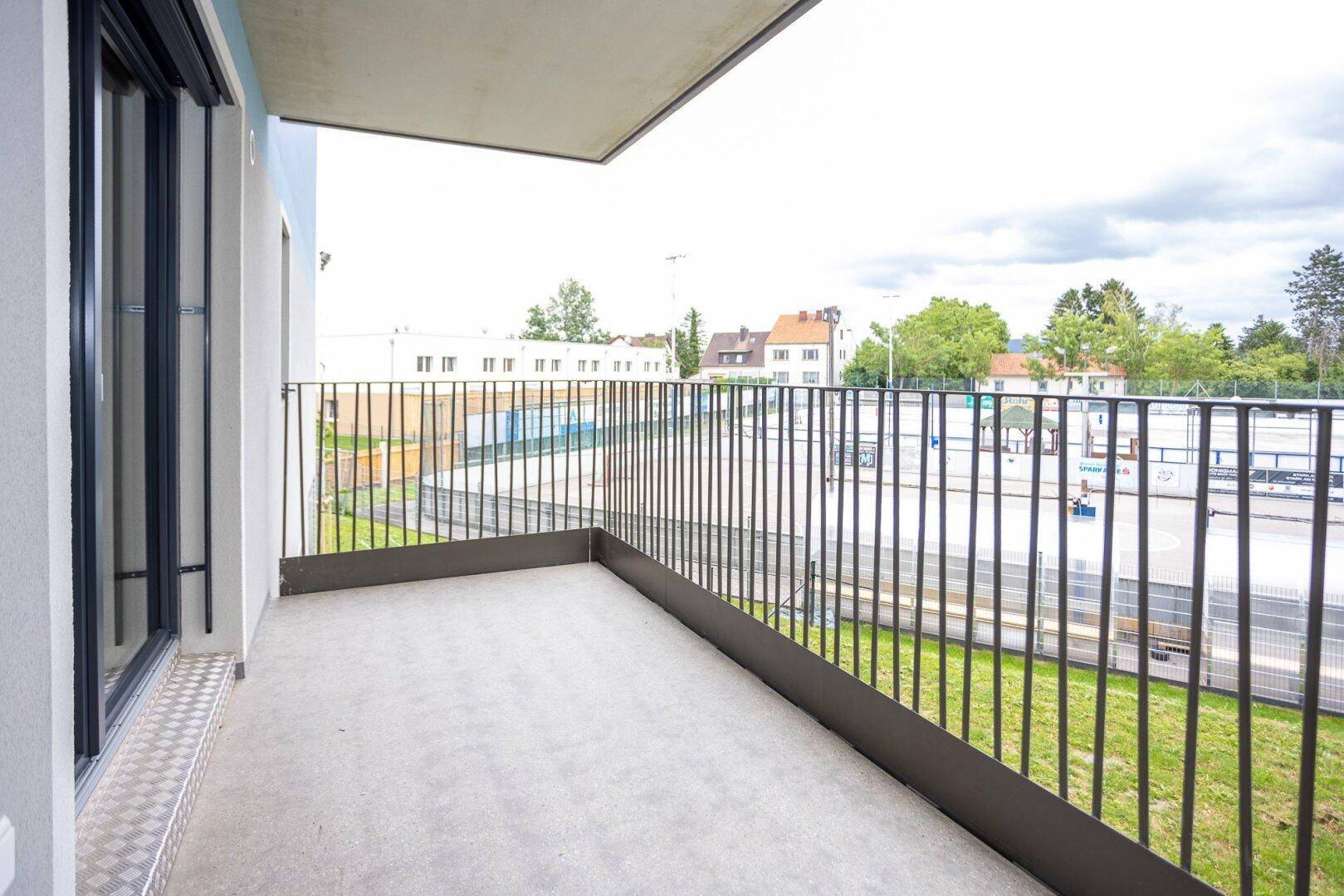 Balkon mit Blick auf die Umgebung und angrenzende Sportanlagen, ideal für Entspannung.