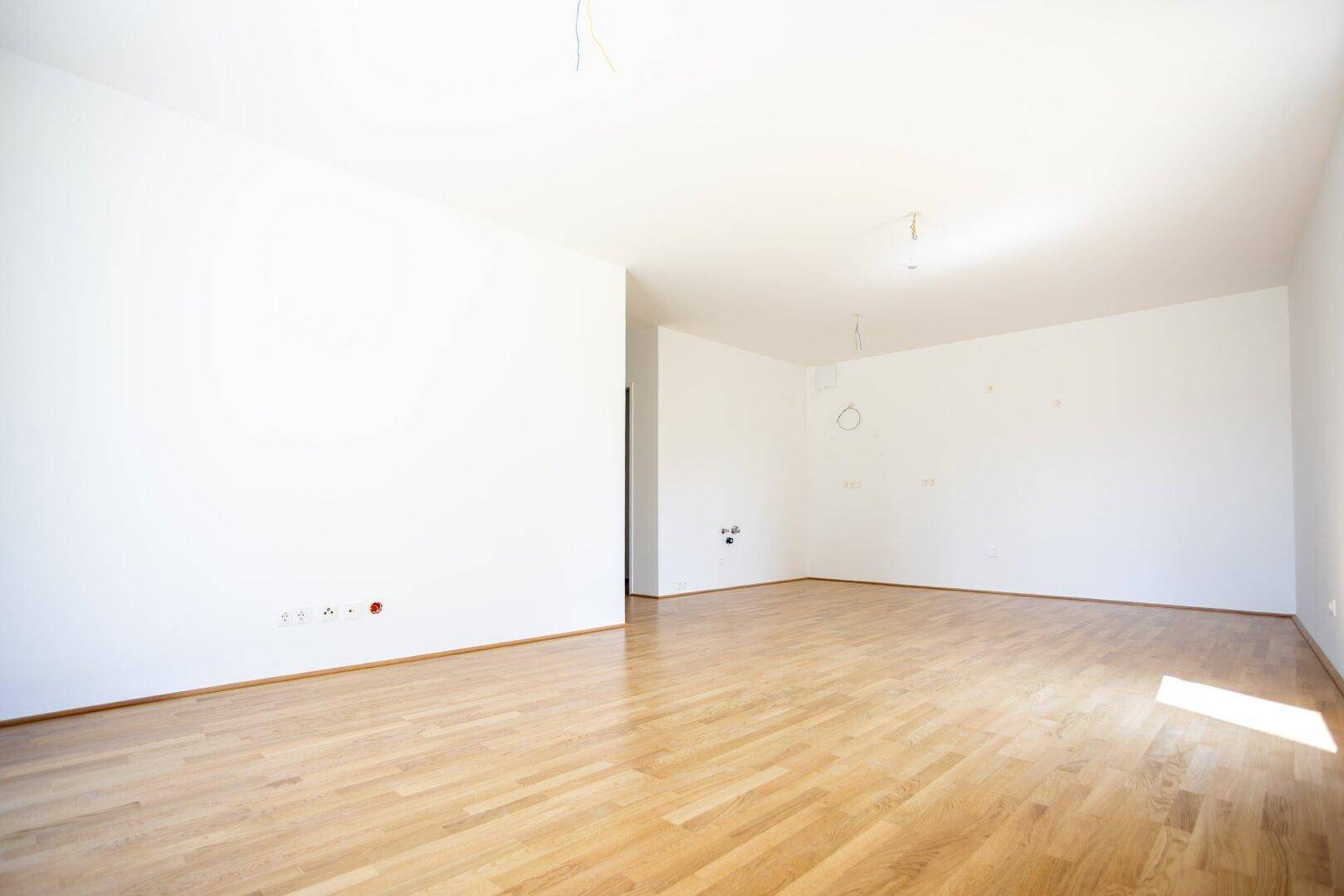 Geräumiges, helles Zimmer mit Parkettboden und weißen Wänden, ideal für individuelle Gestaltung.