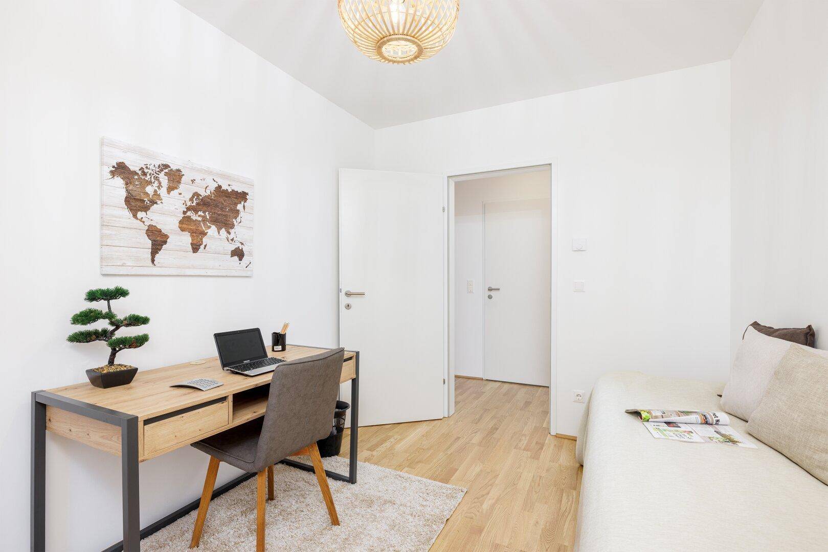 Arbeitszimmer mit Schreibtisch, Tagesbett und Zugang zu weiteren Räumen.