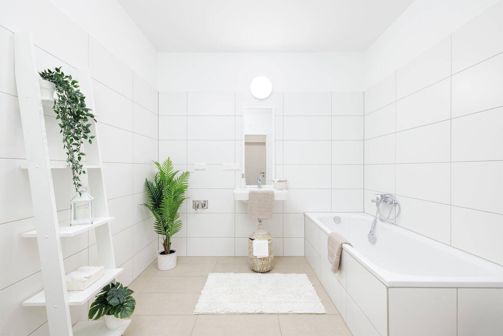 Modernes Badezimmer mit Badewanne, Waschbecken und weißen Fliesen.