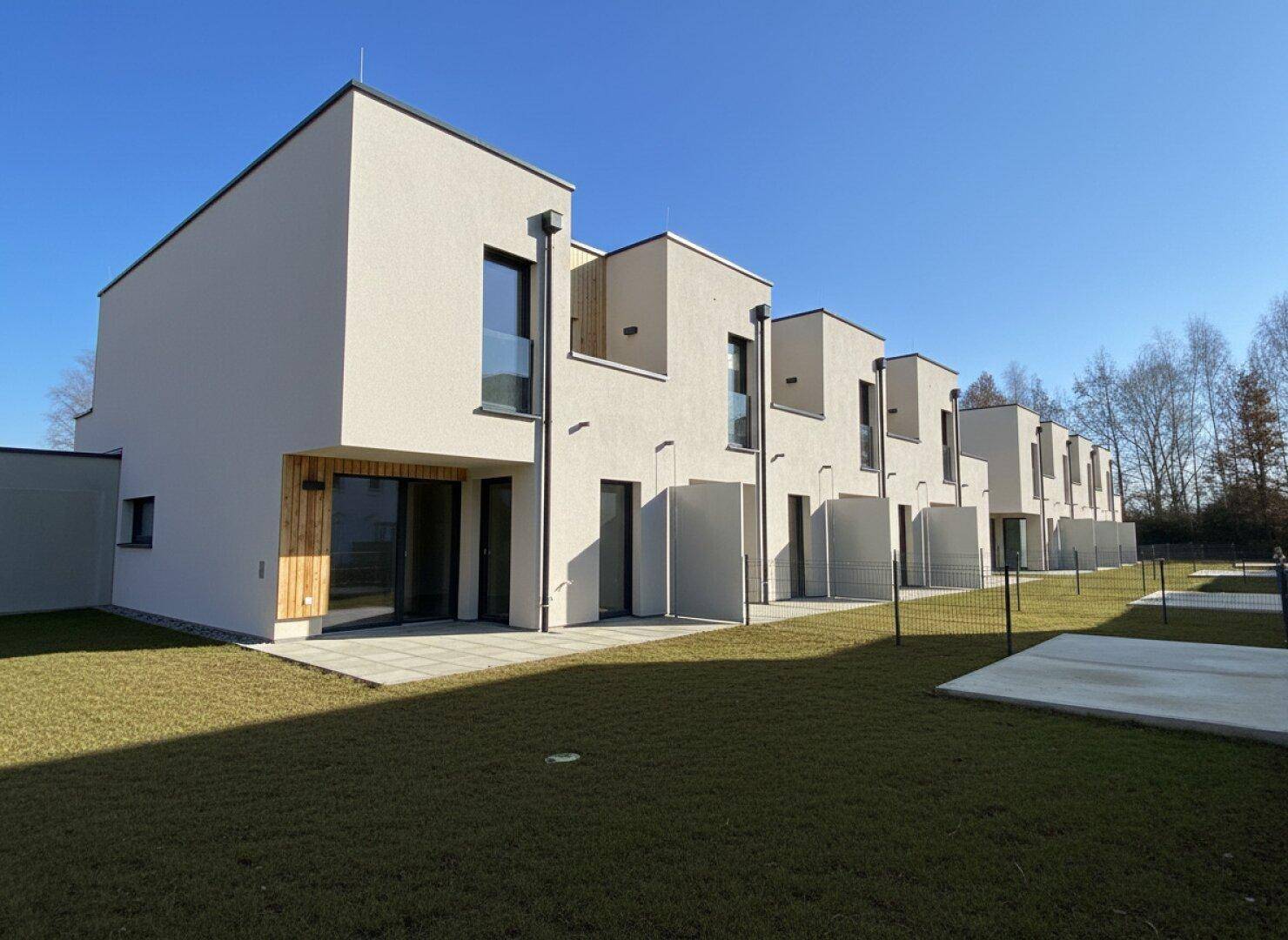 Die Rückseite der modernen Reihenhäuser bietet private Gärten und sonnige Terrassenbereiche.