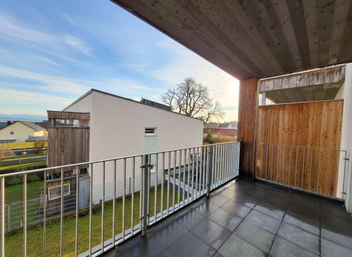 Sonniger Balkon mit Fliesenboden und einem weiten Blick auf die Landschaft.
