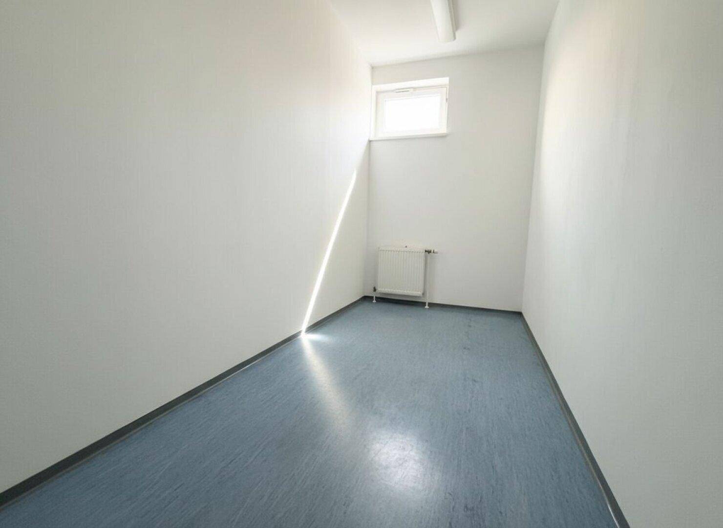 Schmaler Raum mit einem hochgelegenen Fenster, das natürliches Licht hereinlässt, ideal als Abstellraum.