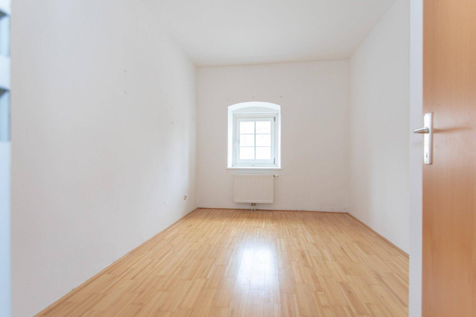 Gemütliches Zimmer mit Parkettboden und einem Fenster, ideal als Schlaf- oder Arbeitszimmer.