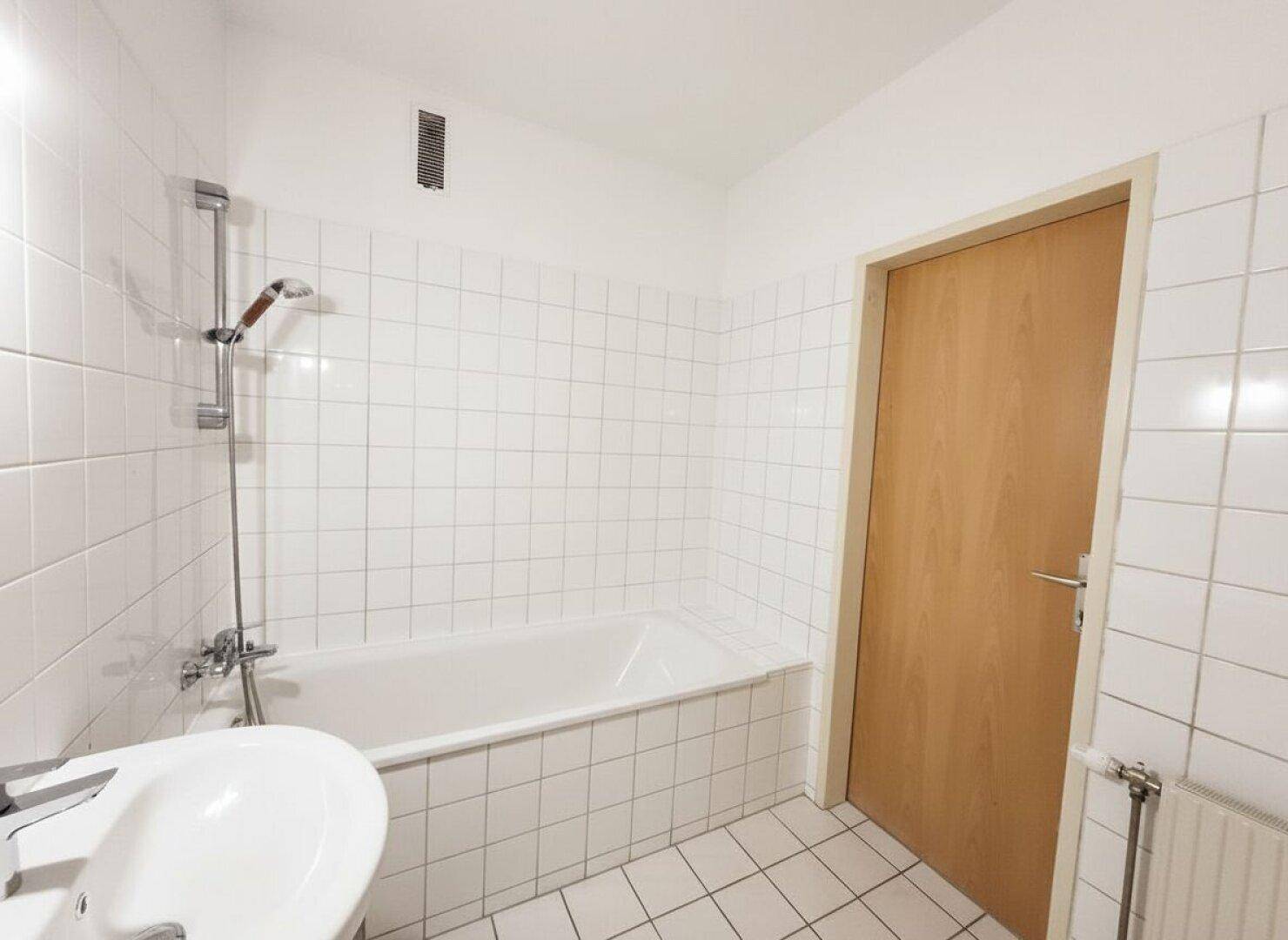 Heller Flur mit Laminatboden und mehreren Türen, verbindet die verschiedenen Räume.