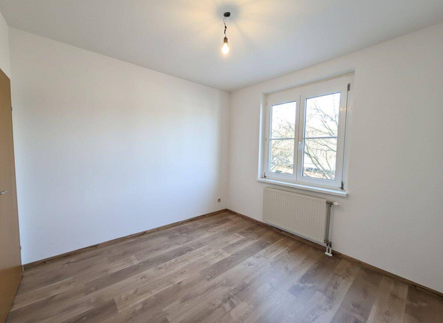 Badezimmer mit weißen Fliesen, Badewanne und Waschbecken, funktional und hell.