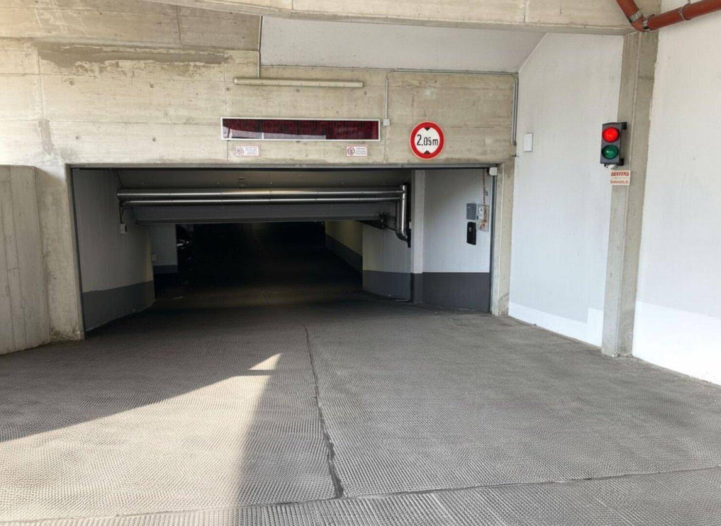 Einfahrt zur Tiefgarage mit Höhenbegrenzung von 2,05 Metern und Ampelsystem für die Zufahrt.