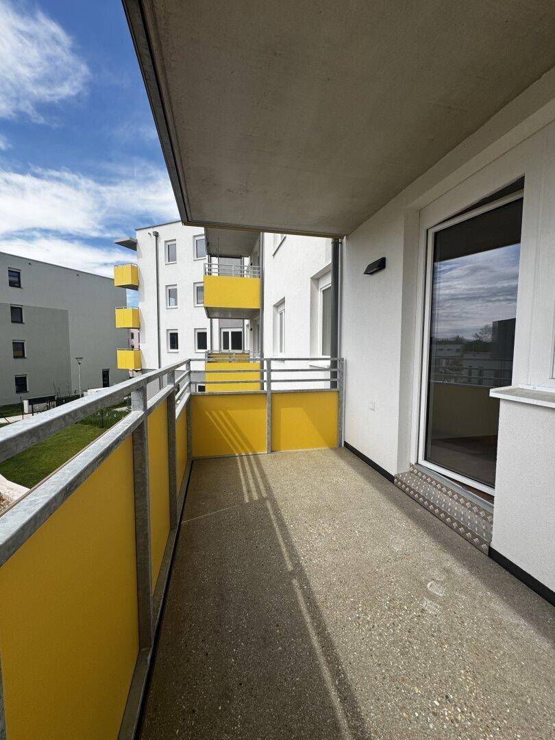Moderner Balkon mit gelben Paneelen und Blick auf die umliegenden Gebäude.
