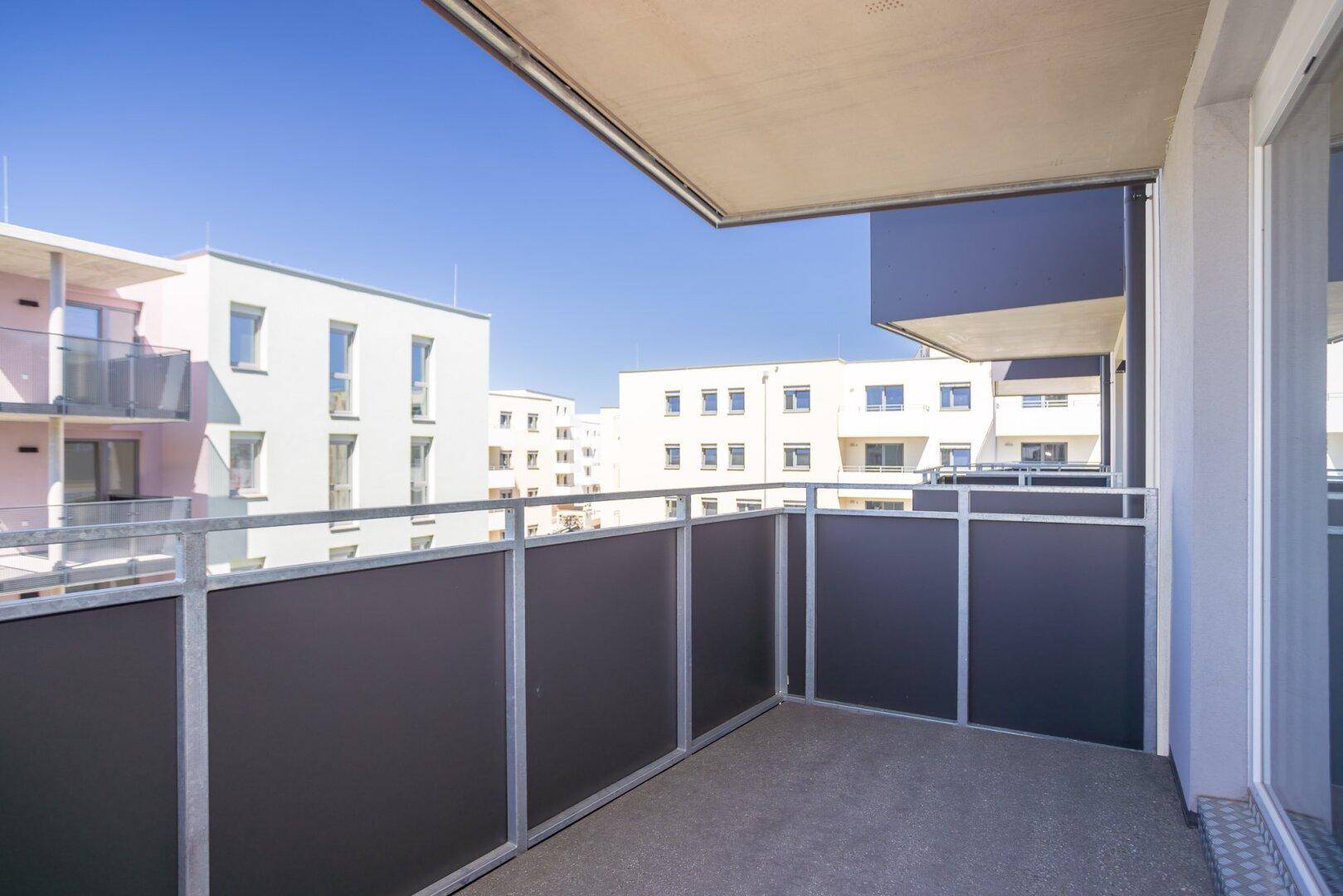 Moderner Balkon mit Metallgeländer und Blick auf die umliegenden Wohngebäude.
