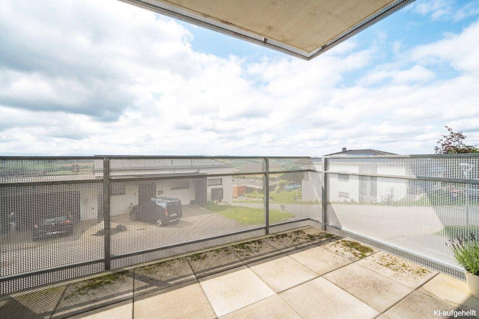 Balkon mit Fliesenboden und perforiertem Metallgeländer, bietet einen weiten Blick über die Umgebung.