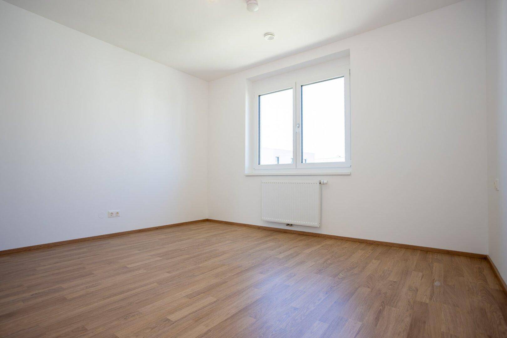 Helles Schlafzimmer mit Laminatboden und ausreichend Platz für individuelle Gestaltung.