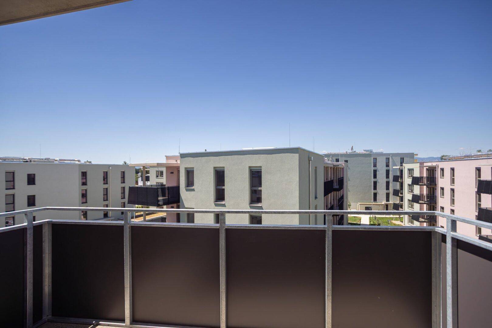 Balkon mit weitem Blick über die umliegenden modernen Wohngebäude und die Stadt.