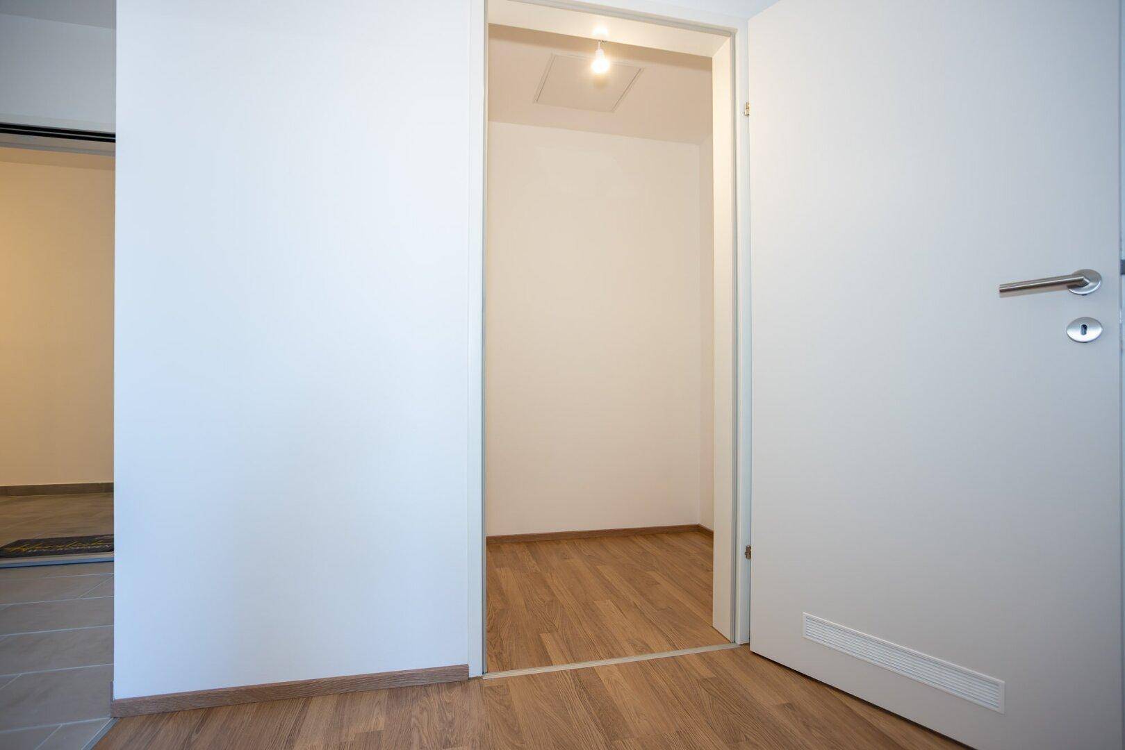 Kleiner Abstellraum mit Laminatboden und einfacher Beleuchtung, ideal für zusätzlichen Stauraum.