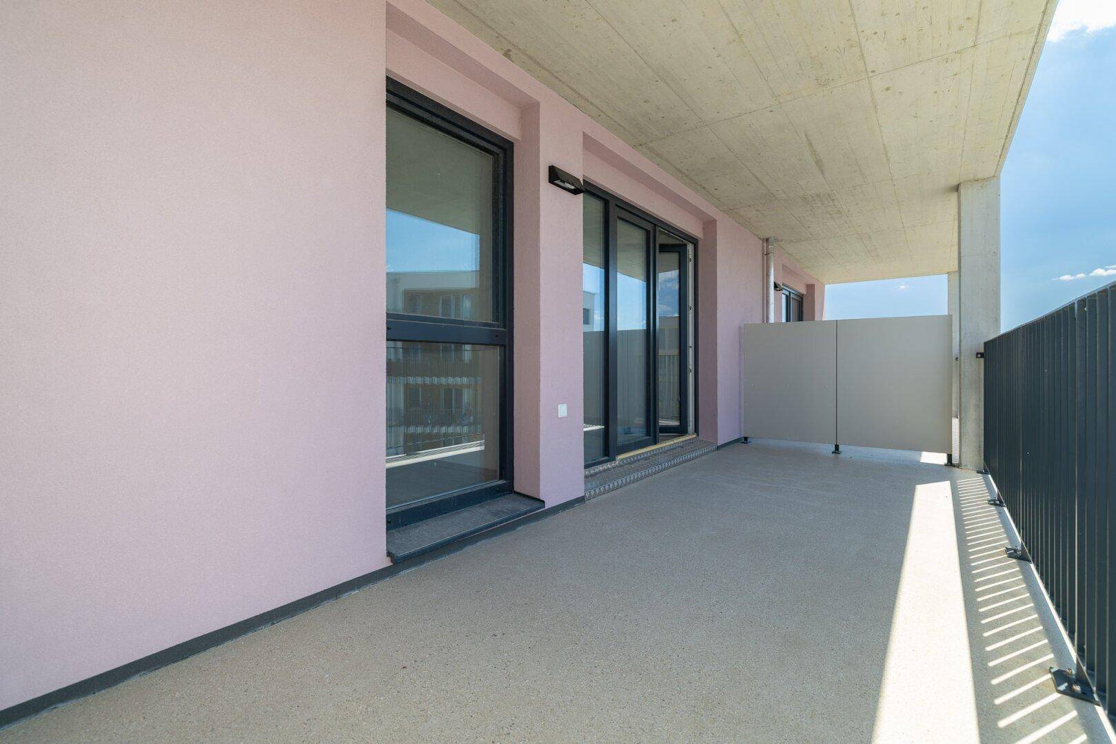 Langer Balkon mit moderner Architektur und Blick auf die Umgebung.