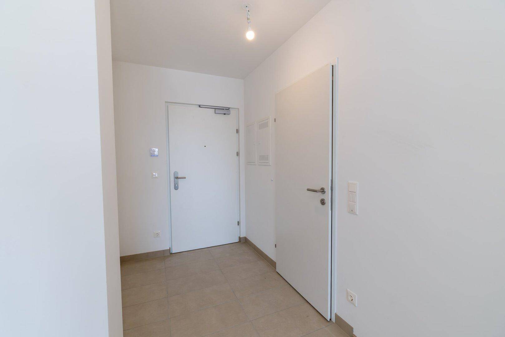 Heller Eingangsbereich mit Fliesenboden und weißen Türen, bietet einen freundlichen Empfang.