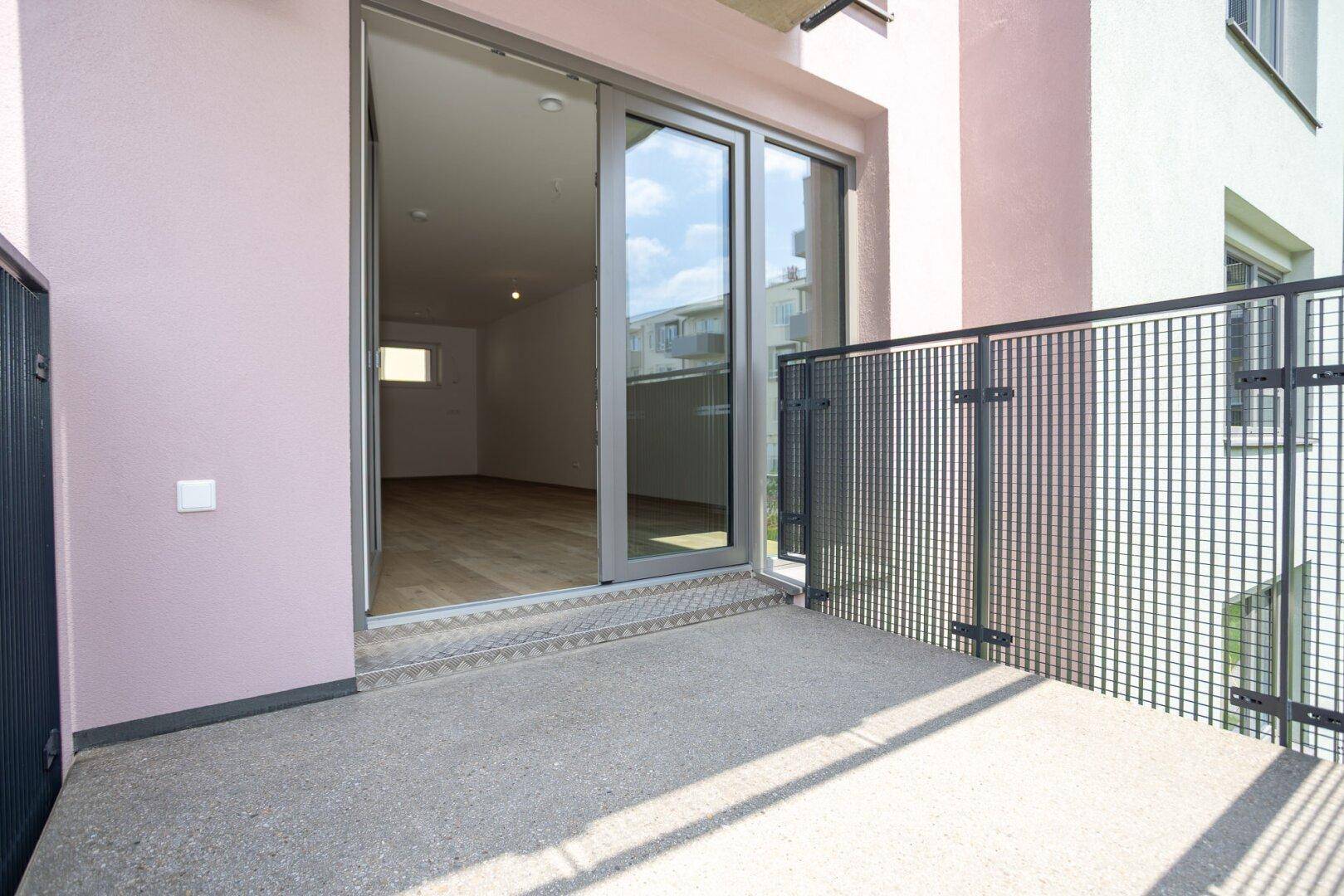 Balkon mit Schiebetür und Blick auf den Innenhof, ideal für entspannte Stunden.