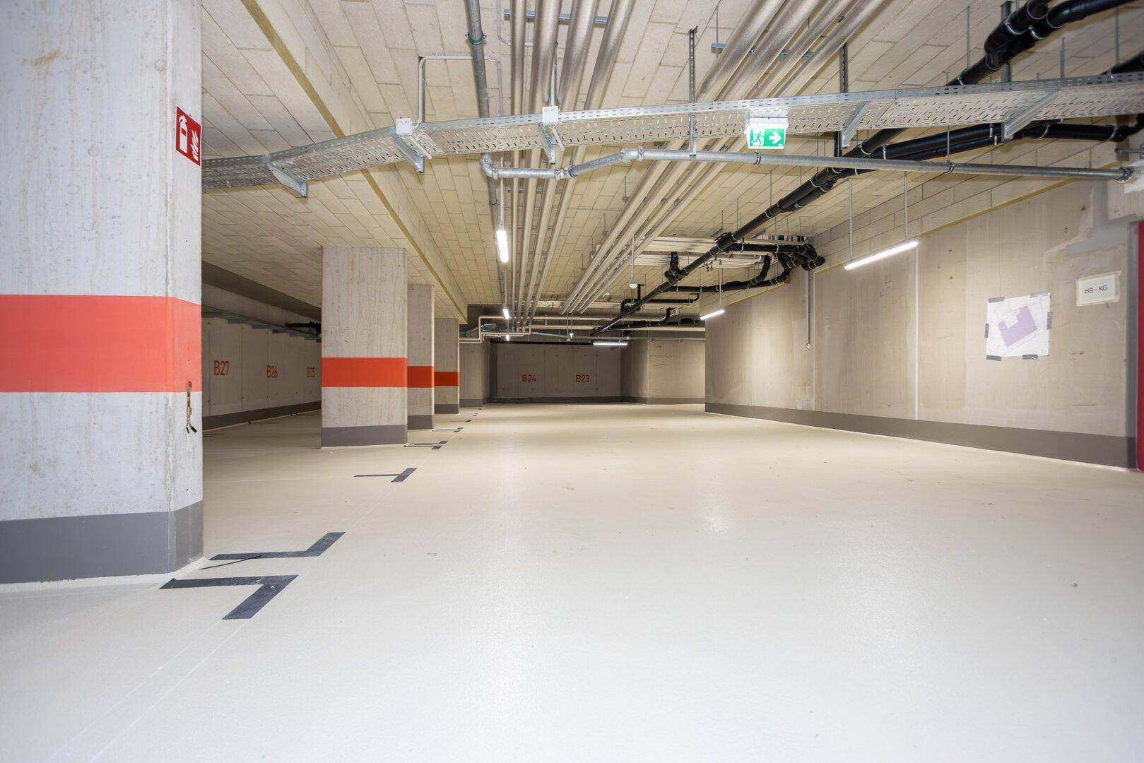 Helle Tiefgarage mit Betonpfeilern und modernen Beleuchtungssystemen.