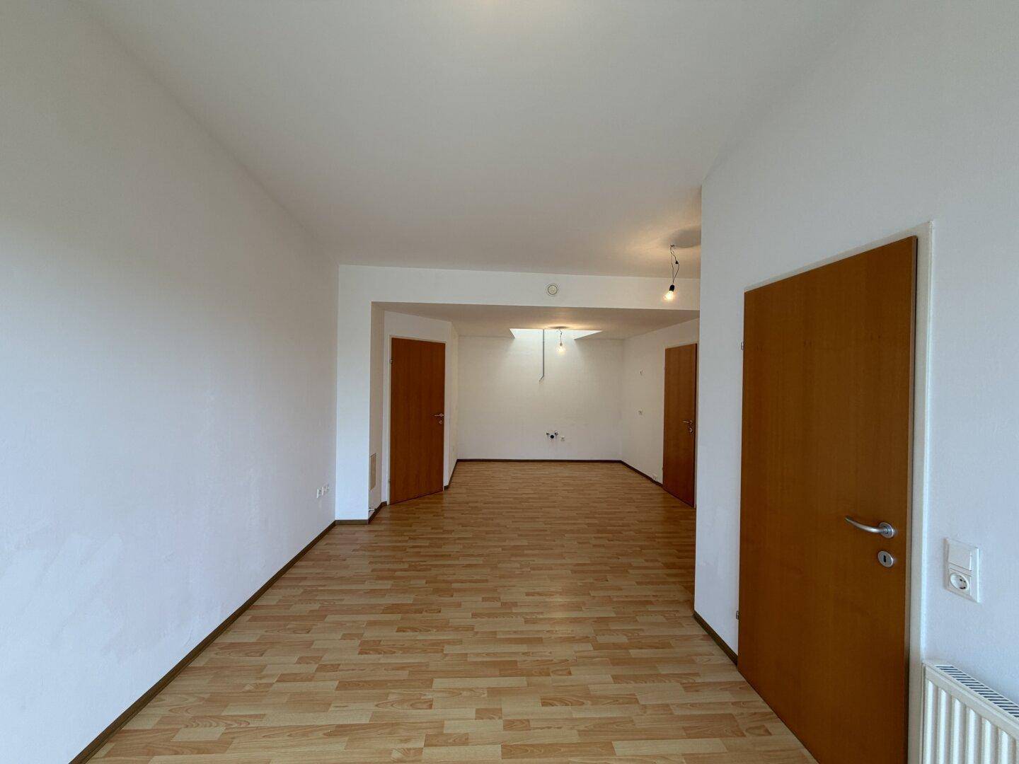Heller Flurbereich mit hellem Laminatboden und mehreren Türen, verbindet verschiedene Räume.
