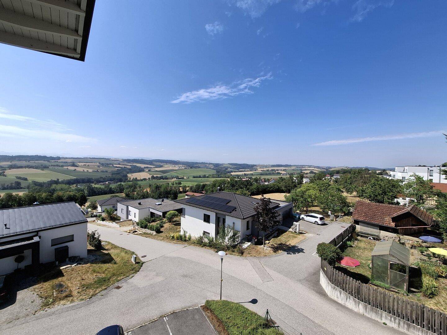 Weitläufiger Blick über eine Wohnsiedlung mit modernen Häusern und grüner Umgebung.